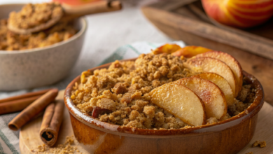 Warm apple crisp with cinnamon-spiced apples and a crunchy golden oat topping in a ceramic baking dish.