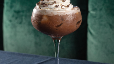 Two chocolate martinis in stemmed glasses, garnished with chocolate shavings and a raspberry.