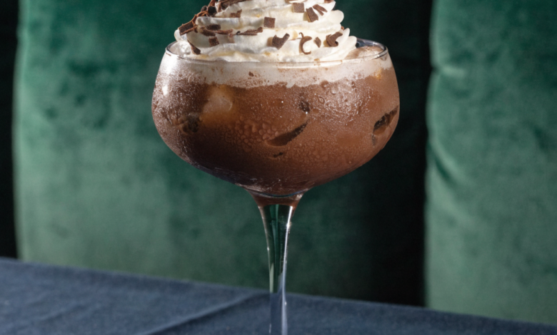 Two chocolate martinis in stemmed glasses, garnished with chocolate shavings and a raspberry.