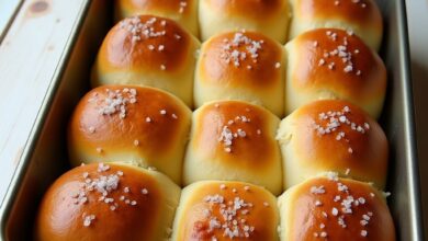 Golden soft pull-apart dinner rolls brushed with butter in a 9x13 baking pan